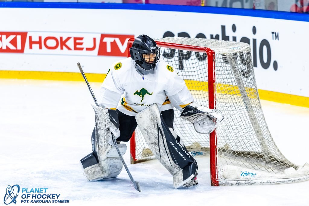 Action-shot photo of Australian ice hockey goaltender Olivia Gargano wearing green, gold, and white Australian national team uniform gear, including a branded helmet, blocker, and goalie pads, positioned alertly on the ice.